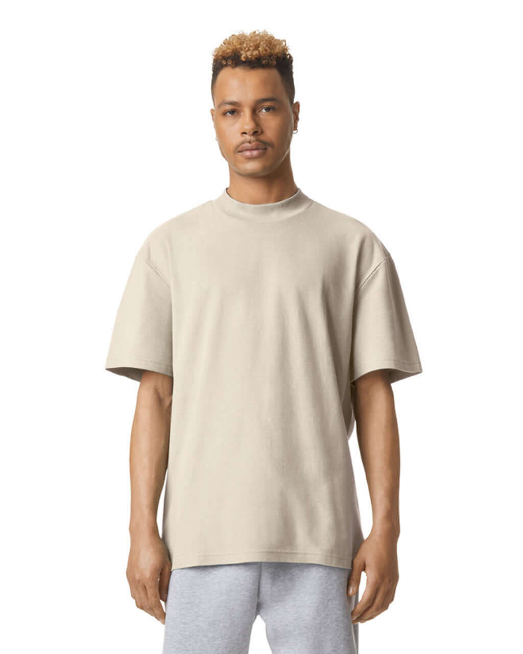Model wearing American Apparel Pique Unisex Mockneck T-Shirt in bone, showcasing comfort and style.