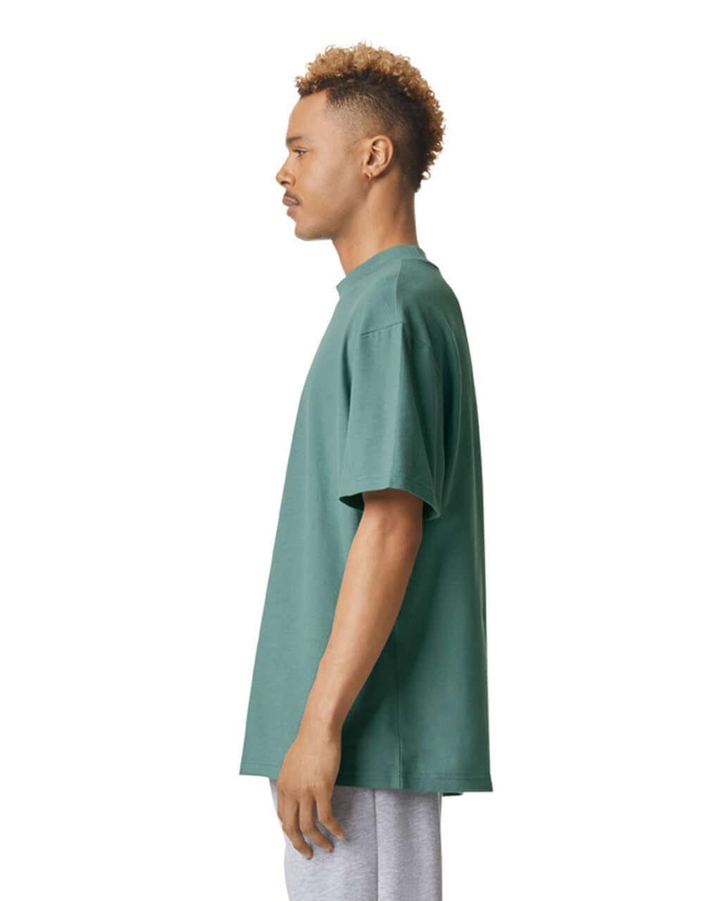 Side view of man wearing American Apparel Pique Unisex Mockneck T-Shirt in arctic, showcasing its relaxed fit.