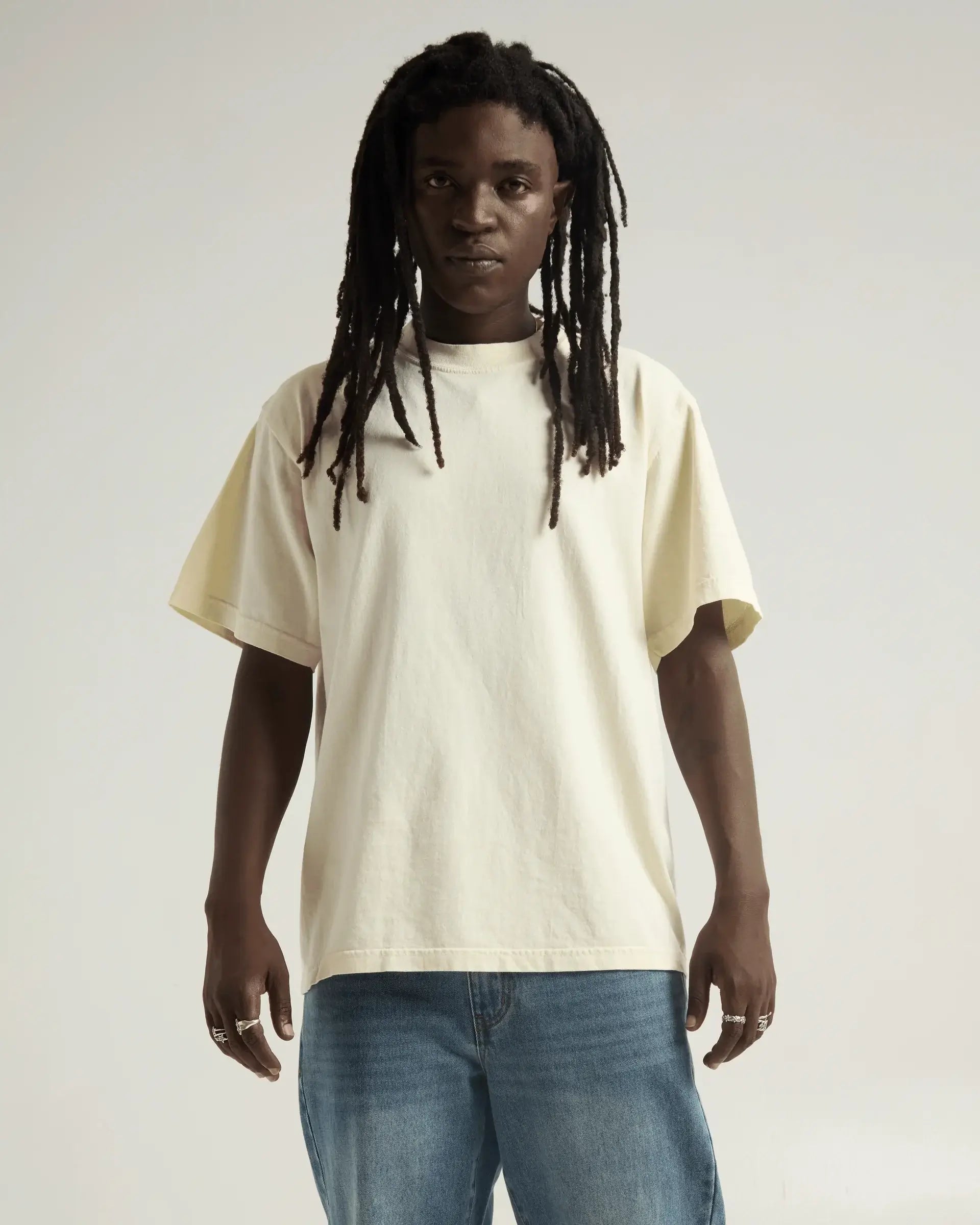 Model wearing SHAKA WEAR MAX heavyweight garment dye oversized tee in vintage cream color.