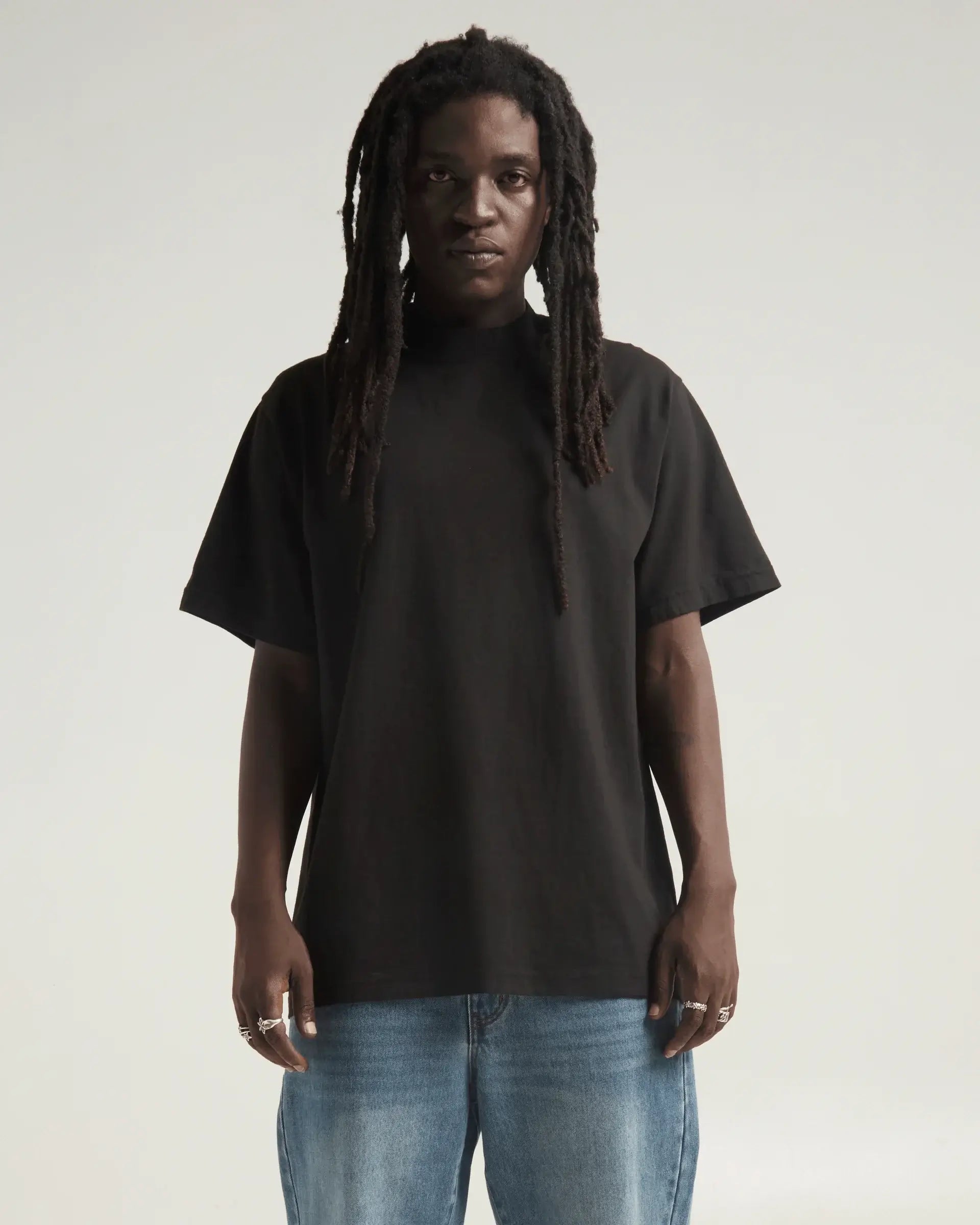 Model wearing black SHAKA WEAR Max Heavyweight Garment Dye Designer Tee with oversized fit and relaxed style.