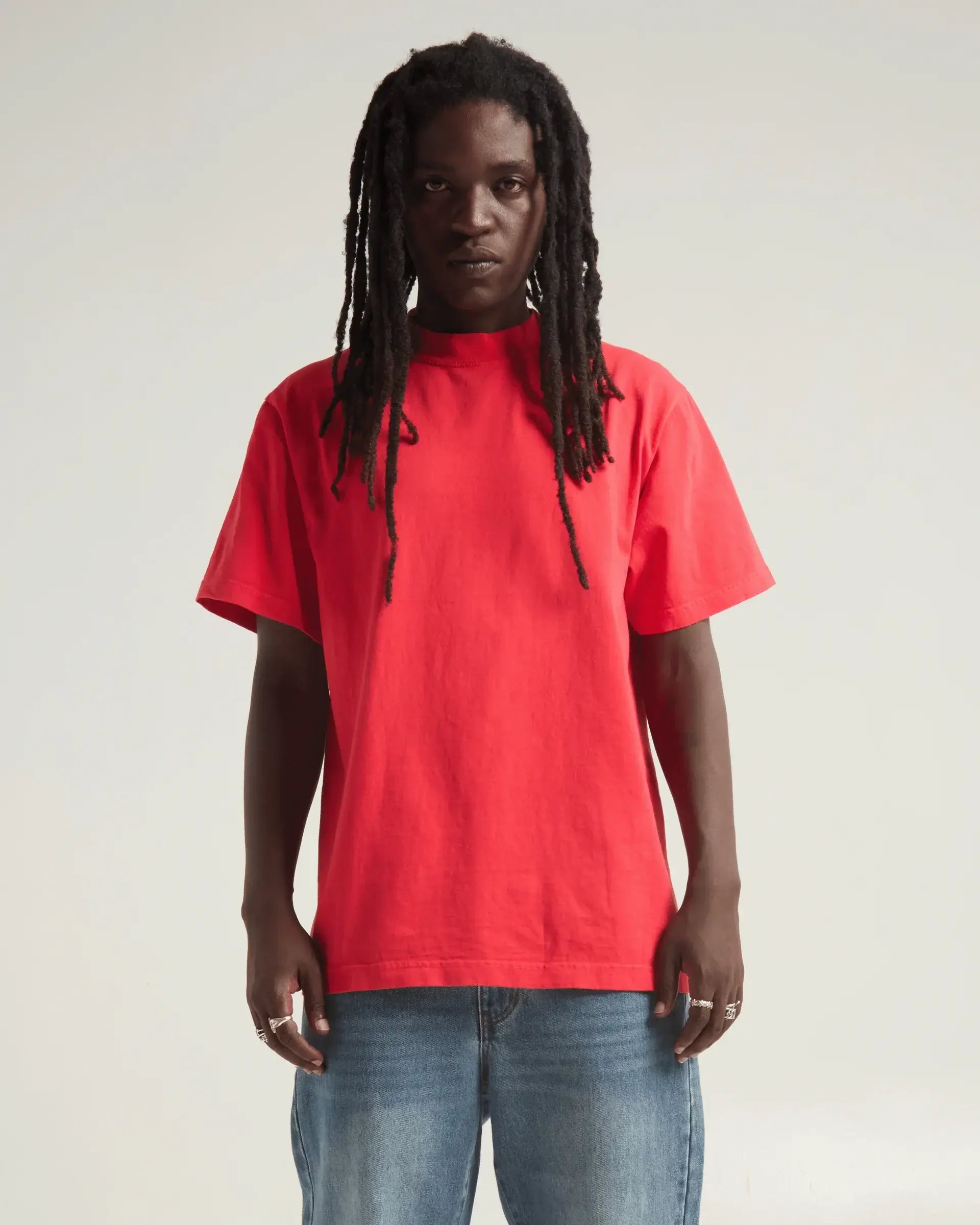 Model wearing SHAKA WEAR Max Heavyweight Garment Dye Designer Tee in red, showcasing its oversized fit and vintage style.