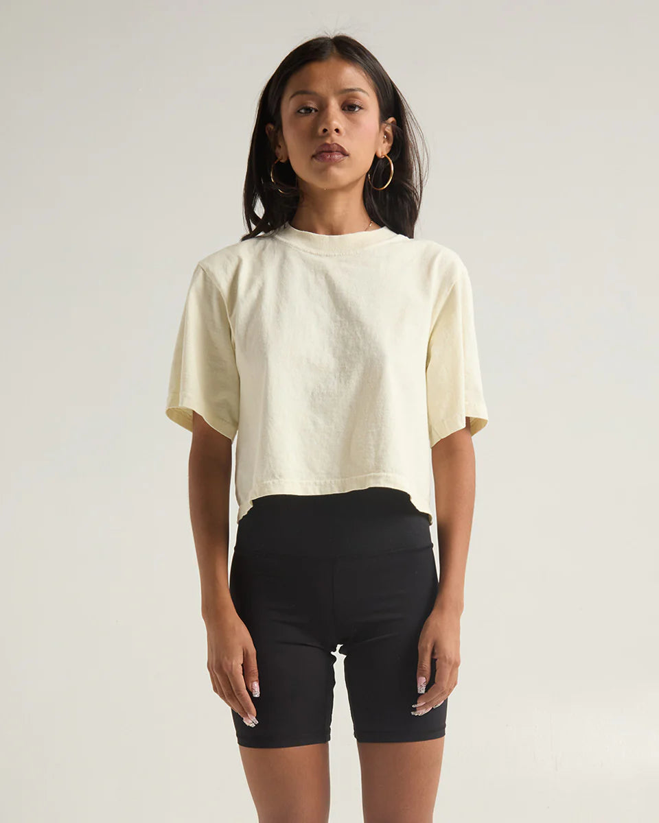 Model wearing yellow garment dye crop top paired with black shorts, showcasing modern style and comfort.