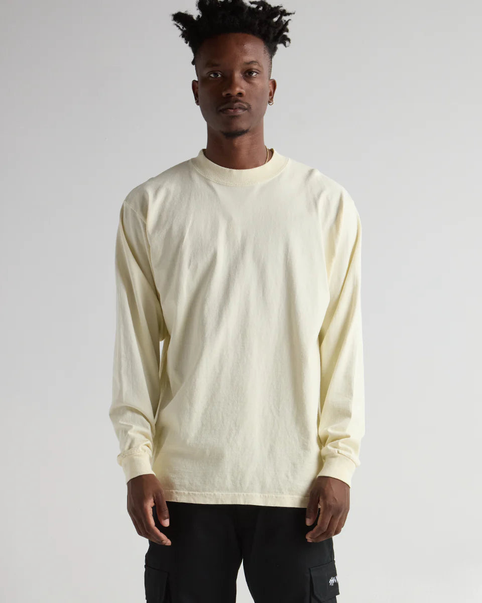 Model wearing the MAX HEAVYWEIGHT GARMENT DYE LONG SLEEVE in pale yellow, showcasing premium streetwear style.