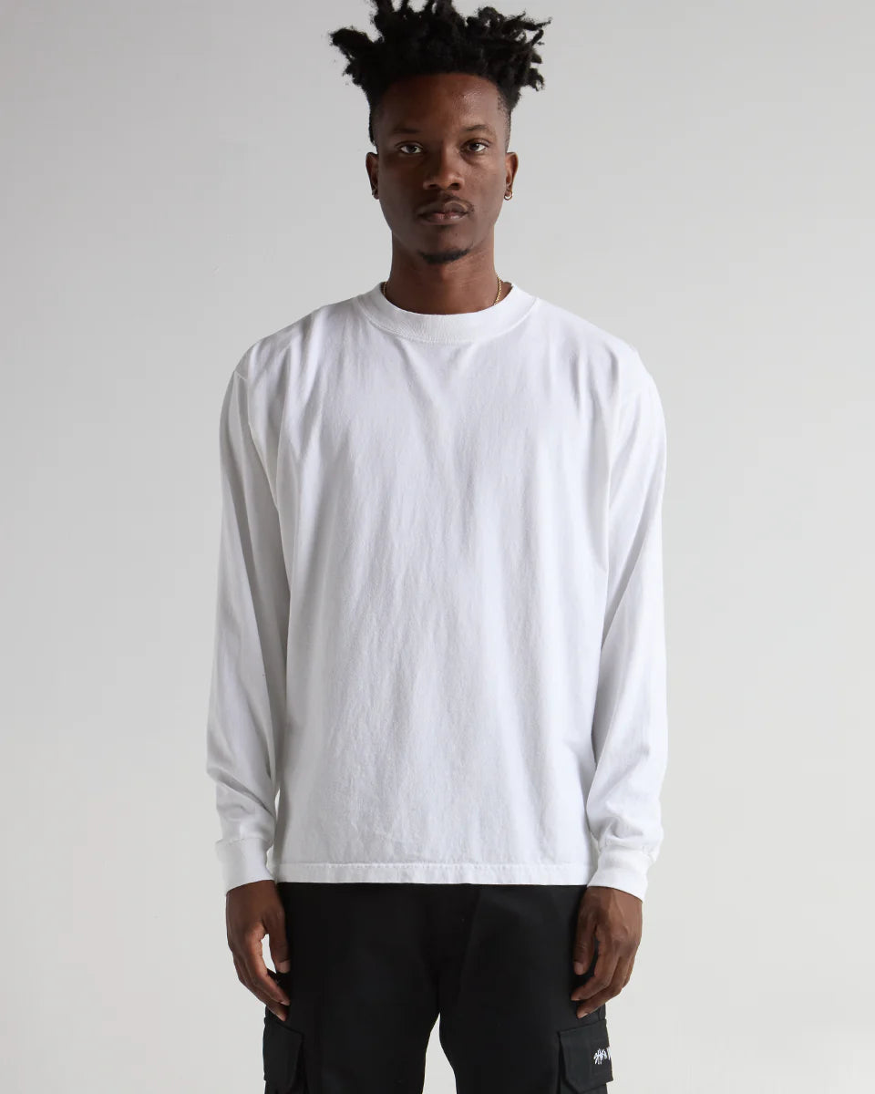 Model wearing MAX HEAVYWEIGHT GARMENT DYE LONG SLEEVE streetwear in white, showcasing modern design and comfort.