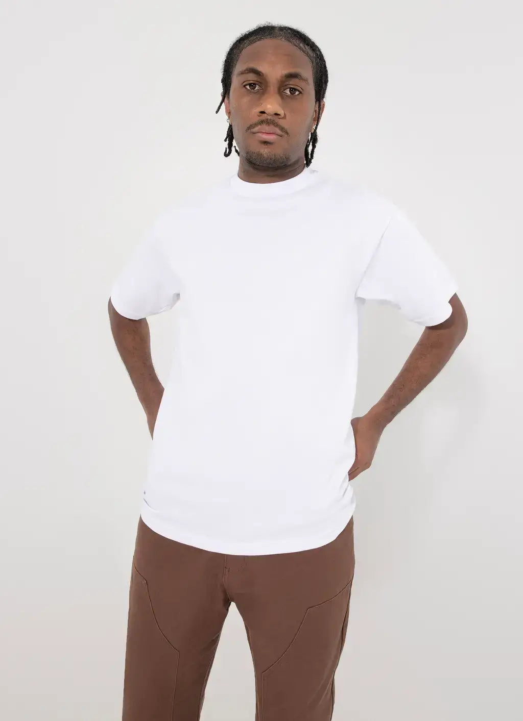 Model wearing a white Pro Club men's comfort cotton short sleeve t-shirt paired with brown pants.