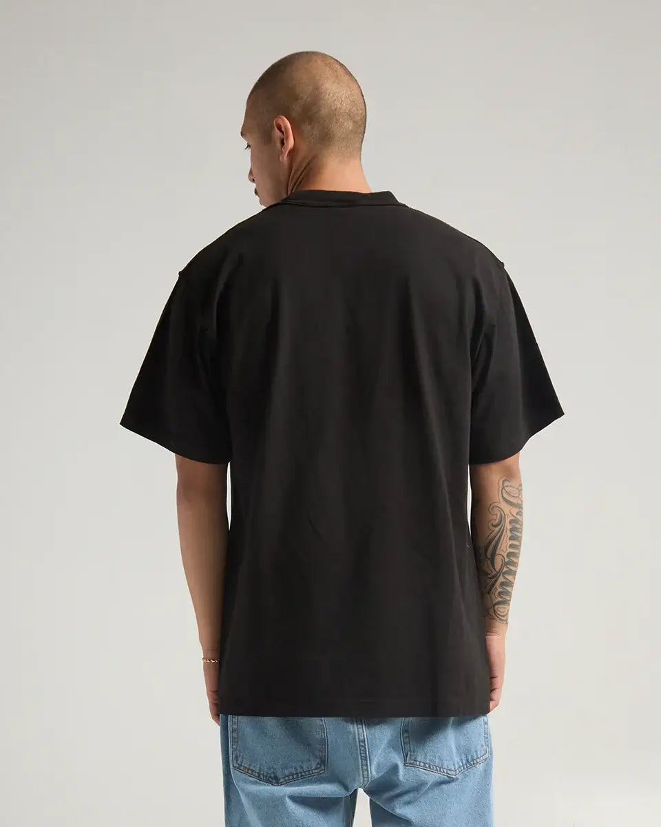 Model wearing SHAKA WEAR GARMENT DYE REVERSE TEE from the back, showcasing its unique heavyweight fabric and reverse stitching.