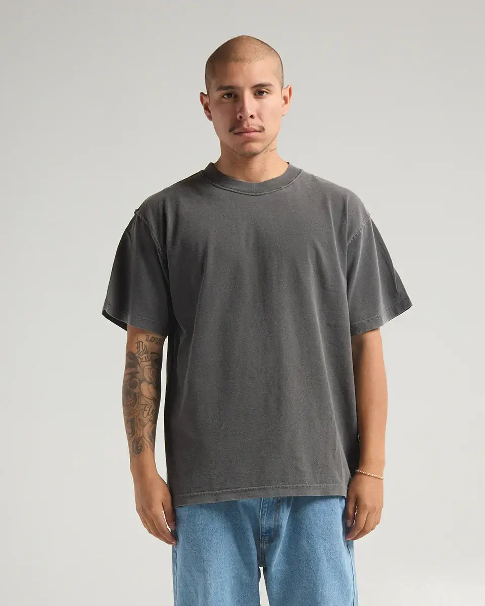 Model wearing the SHAKA WEAR GARMENT DYE REVERSE TEE in faded gray, showcasing its unique heavyweight fabric and reverse stitching.