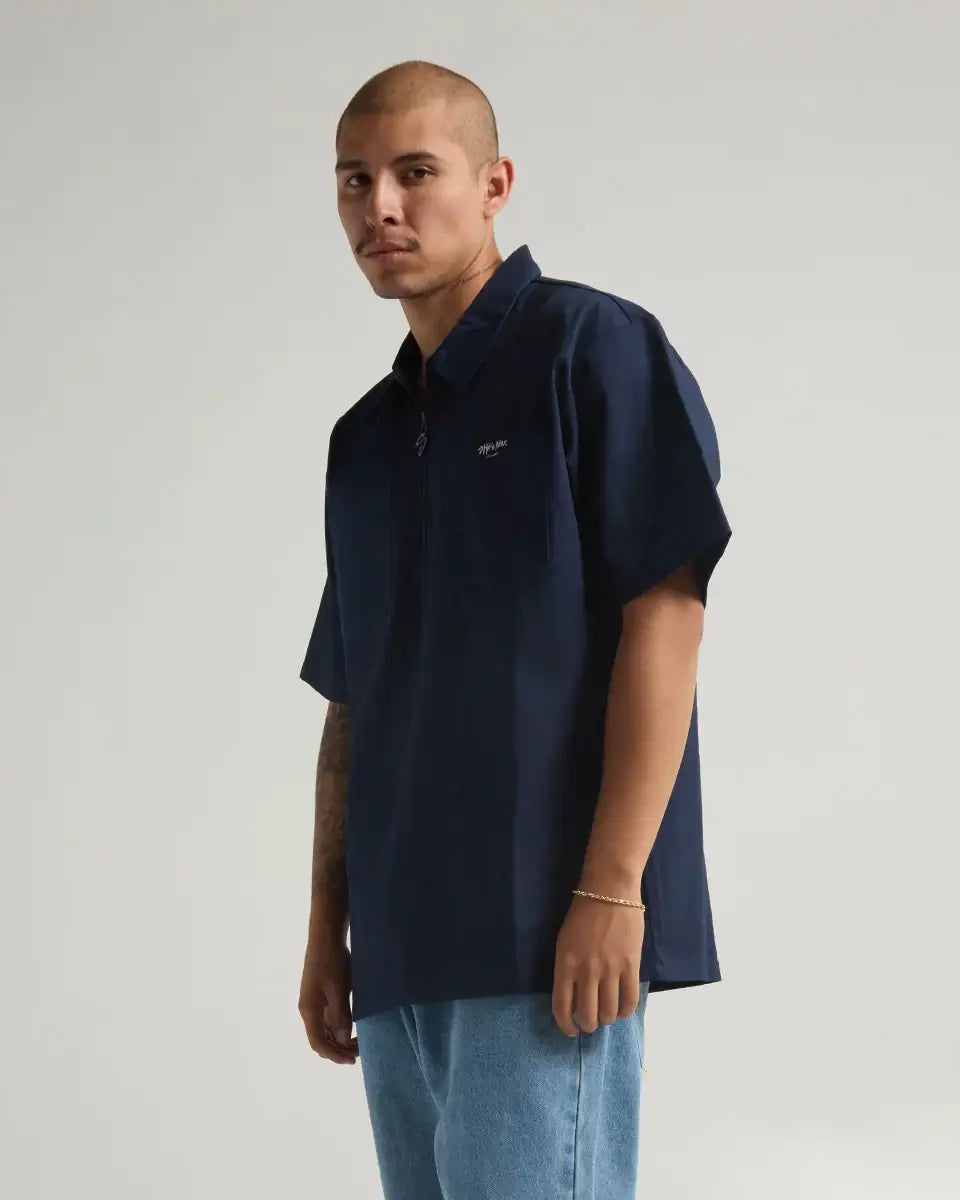 Model wearing SHAKA WEAR WORK SHIRT in navy, showcasing its durable fabric and stylish design.