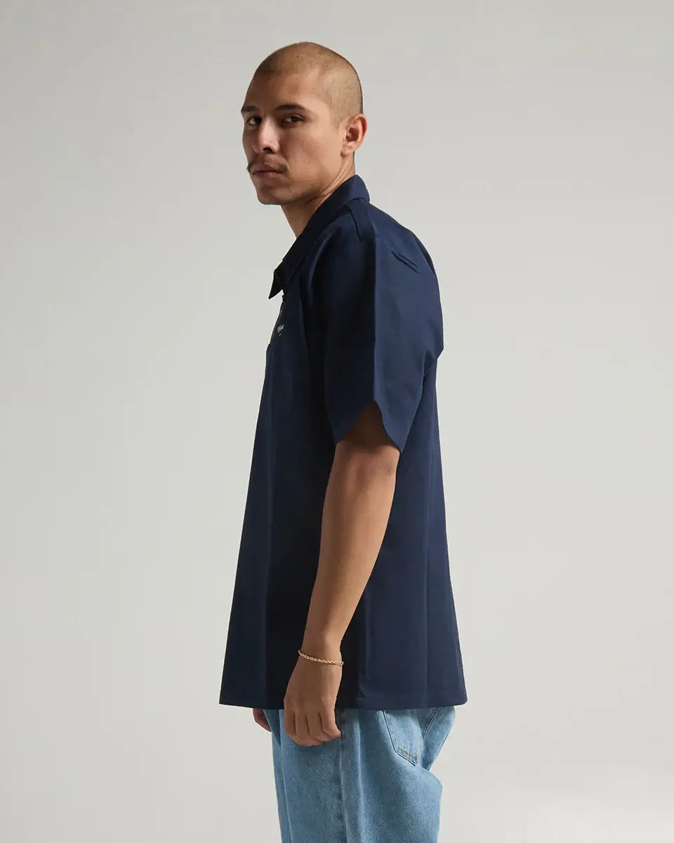 Side view of a model wearing the navy SHAKA WEAR WORK SHIRT, showcasing its stylish design and durable fabric.