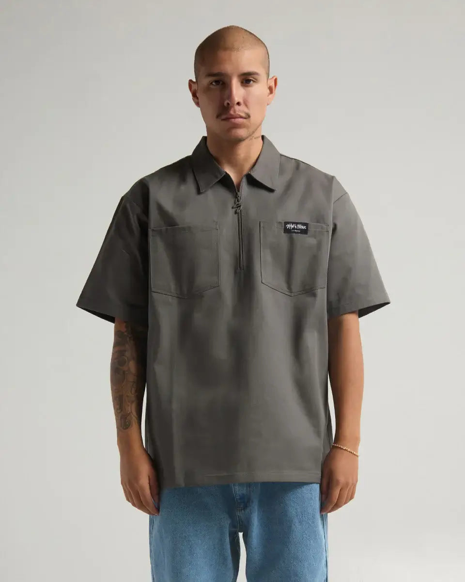 Man wearing SHAKA WEAR WORK SHIRT, a durable zippered work shirt in gray, perfect for professional and casual settings.